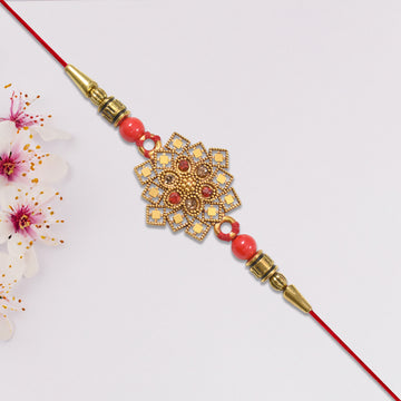 Traditional Golden Floral Rakhi With Intricate Design And Red Beads On Red Thread